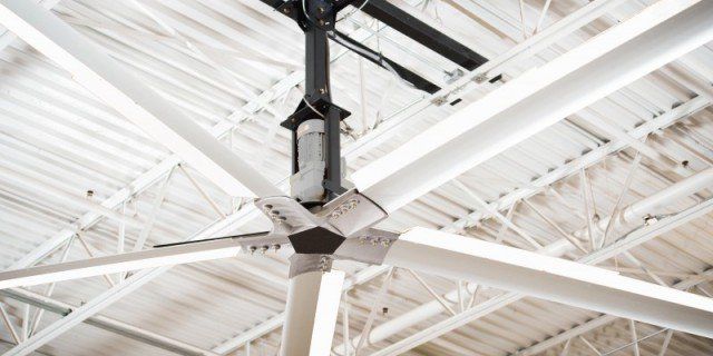 A large ceiling fan is hanging from the ceiling of a building.