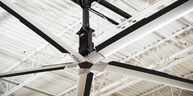 A large ceiling fan is hanging from the ceiling of a building.