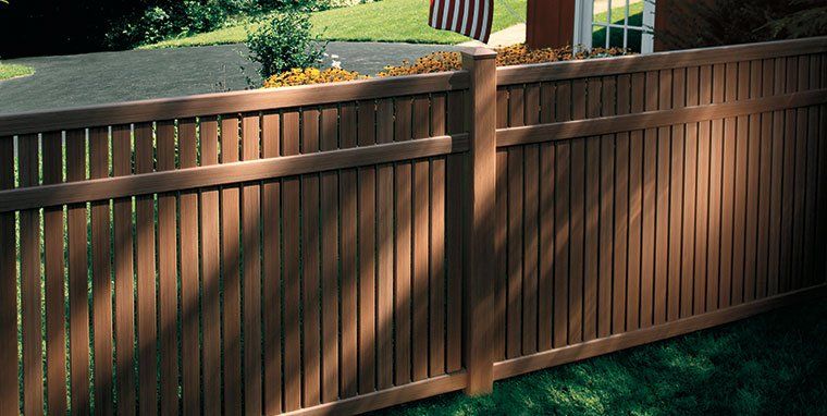 Brown wooden fence in a yard with an American flag visible in Lititz, PA.
