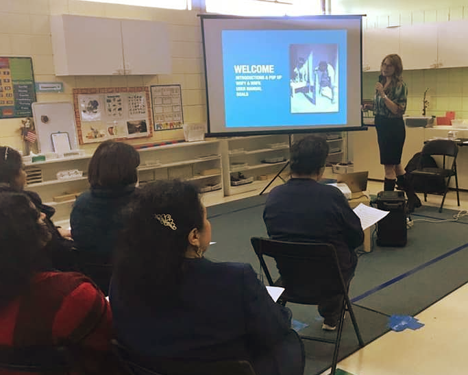 A woman is giving a presentation to a group of people