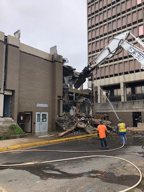 Collapsed building with firefighters and rubble after a structural collapse on a city street