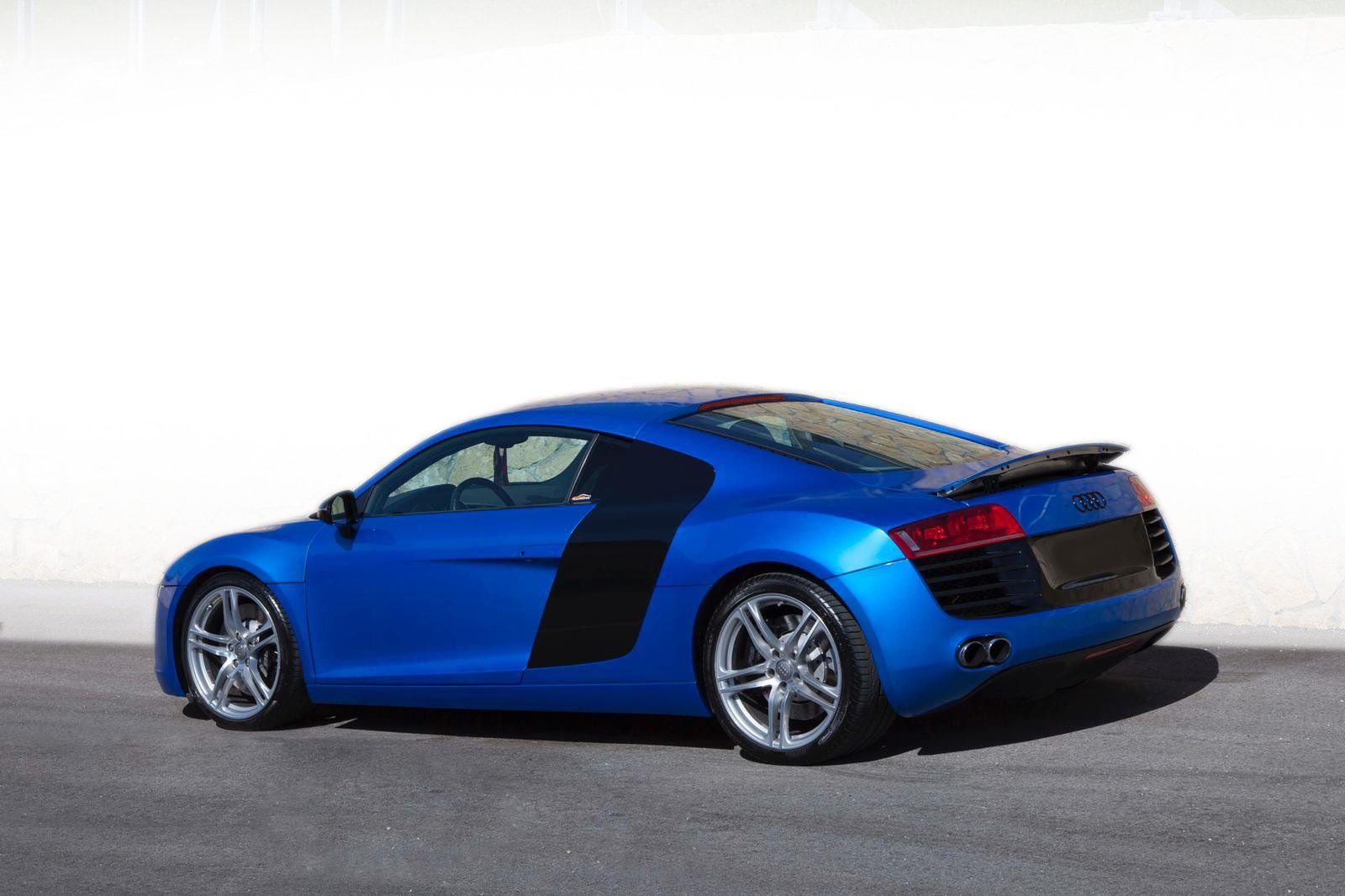 Auto sportiva Audi R8 blu su asfalto su sfondo bianco.