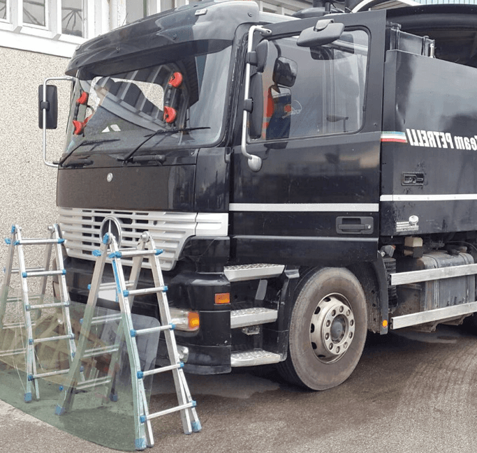 Camion nero con scale, parcheggiato vicino a un edificio.