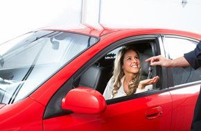 women in red car