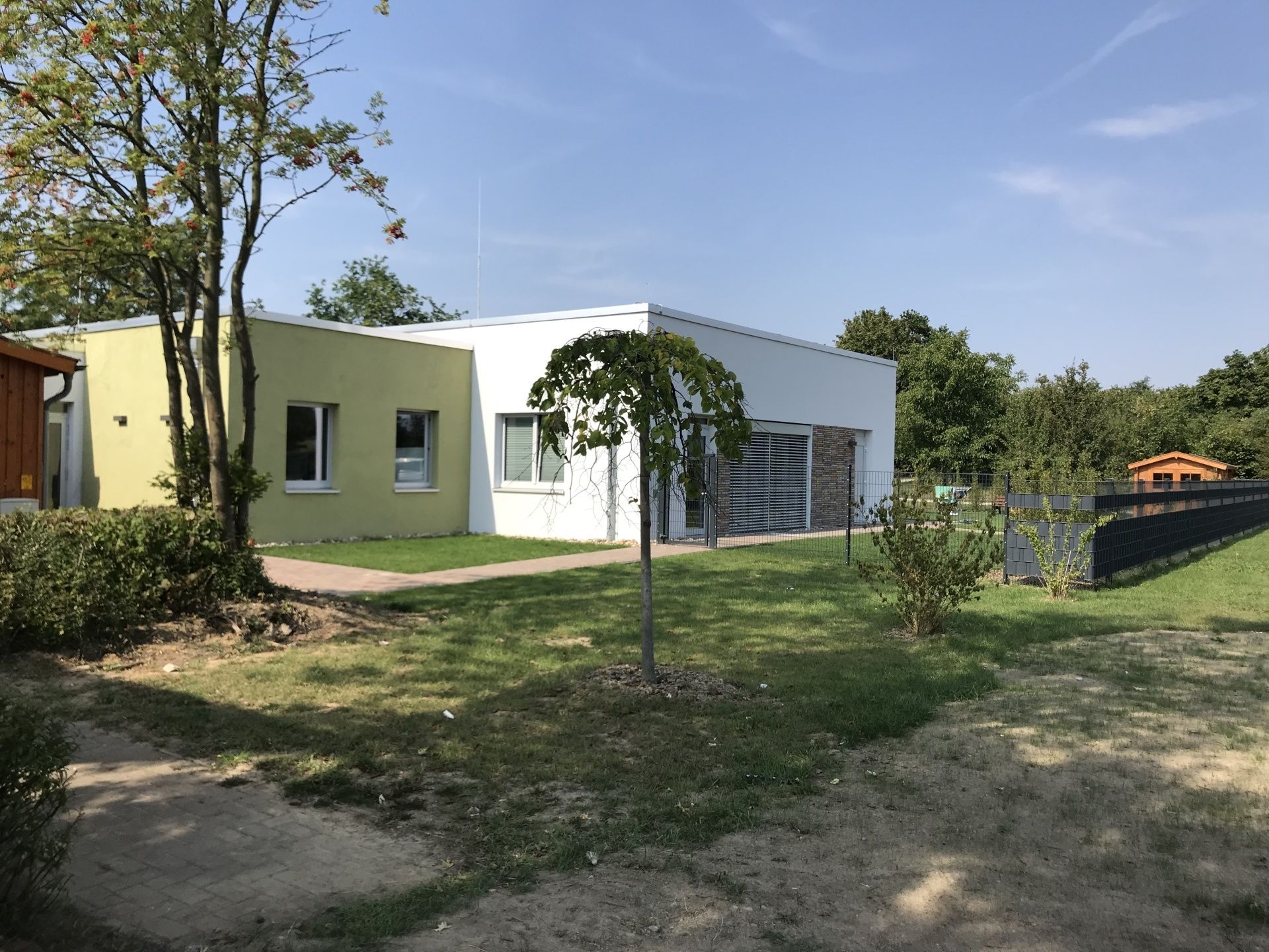 Ein Haus mit viel Gras und Bäumen davor.