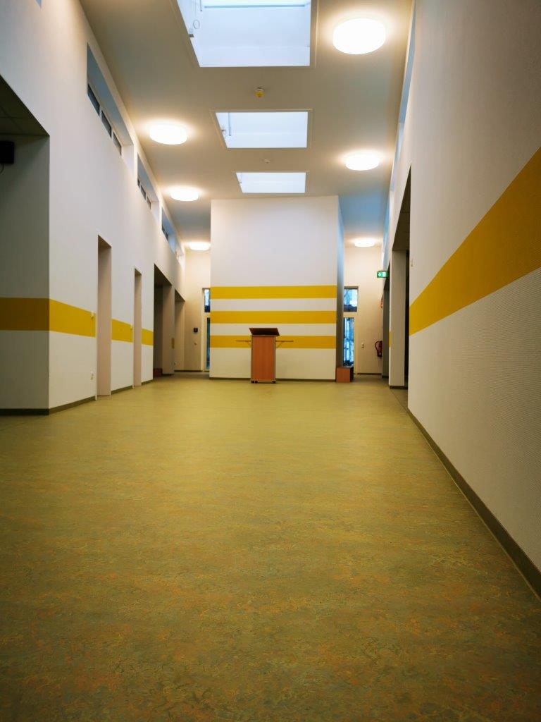 Ein langer Flur mit gelben und weißen Streifen an den Wänden