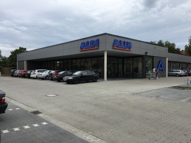 Eine Reihe von Autos parken vor einem Aldi-Laden