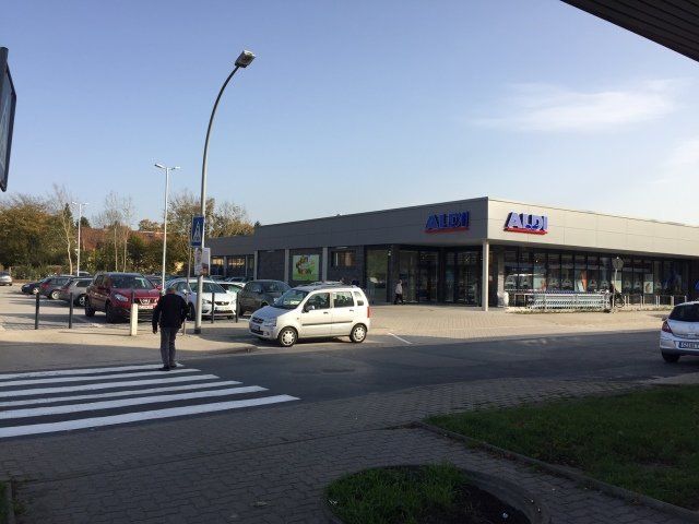 Ein Auto steht vor einem Laden mit der Aufschrift „Alma“