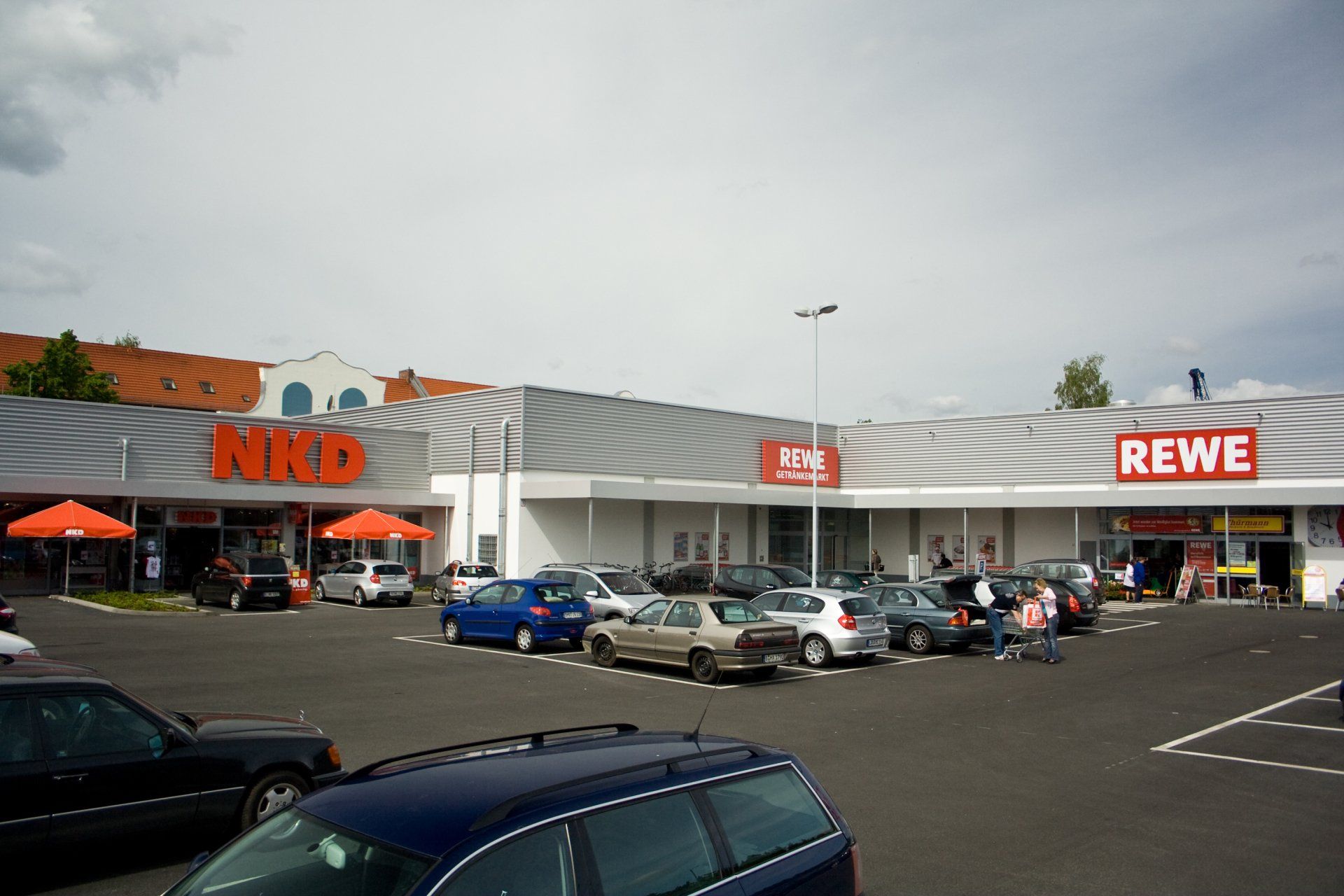 Viele Autos parken vor einem Rewe-Markt