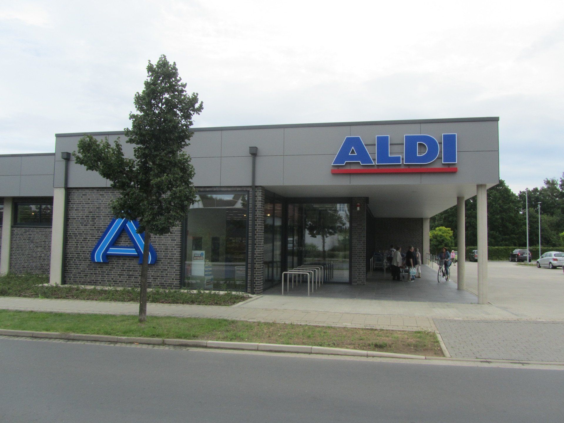 Die Vorderseite eines Aldi-Ladens mit einem Baum davor