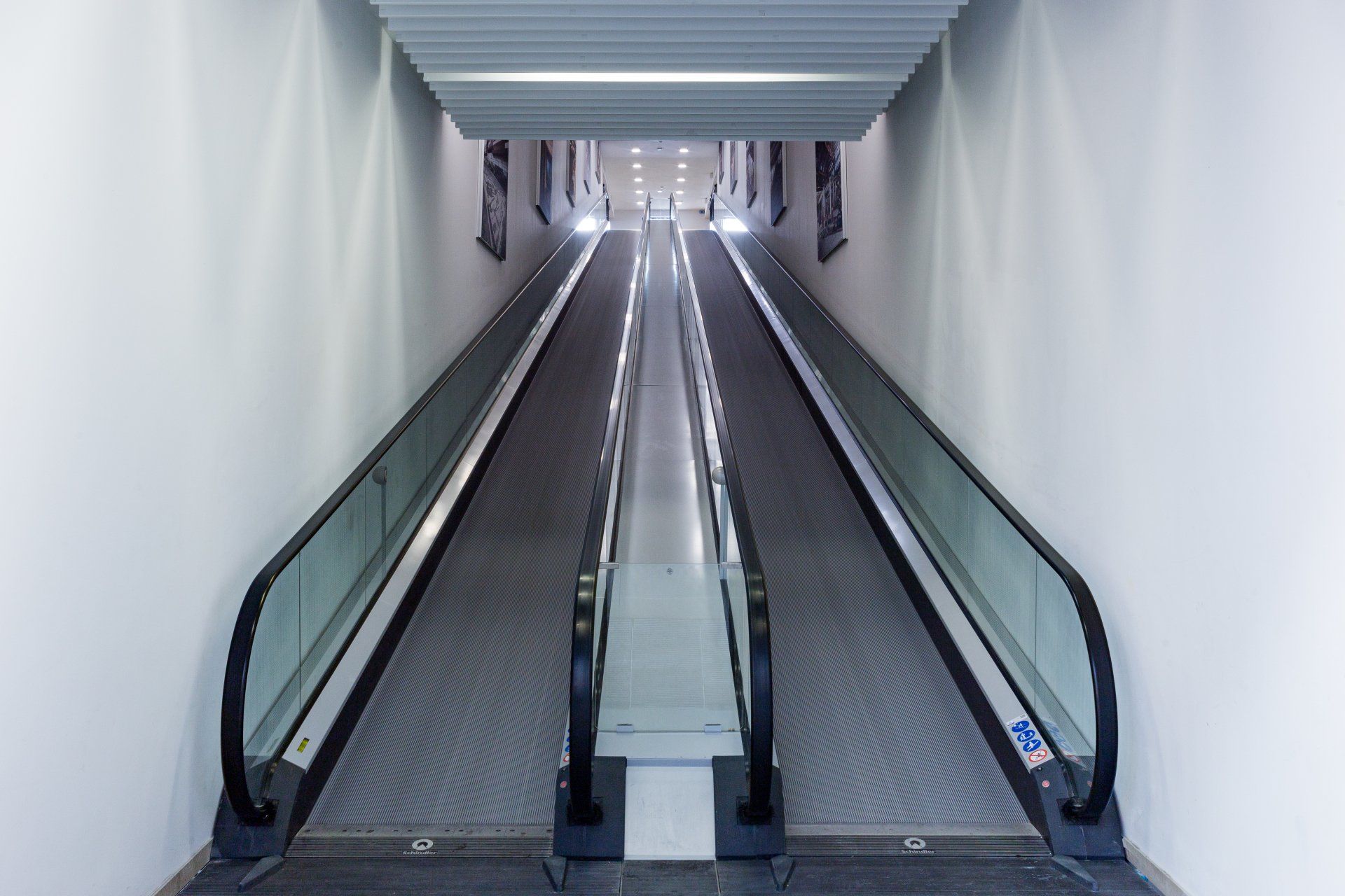 Eine Reihe von Rolltreppen, die einen Tunnel in einem Gebäude hinunterführen