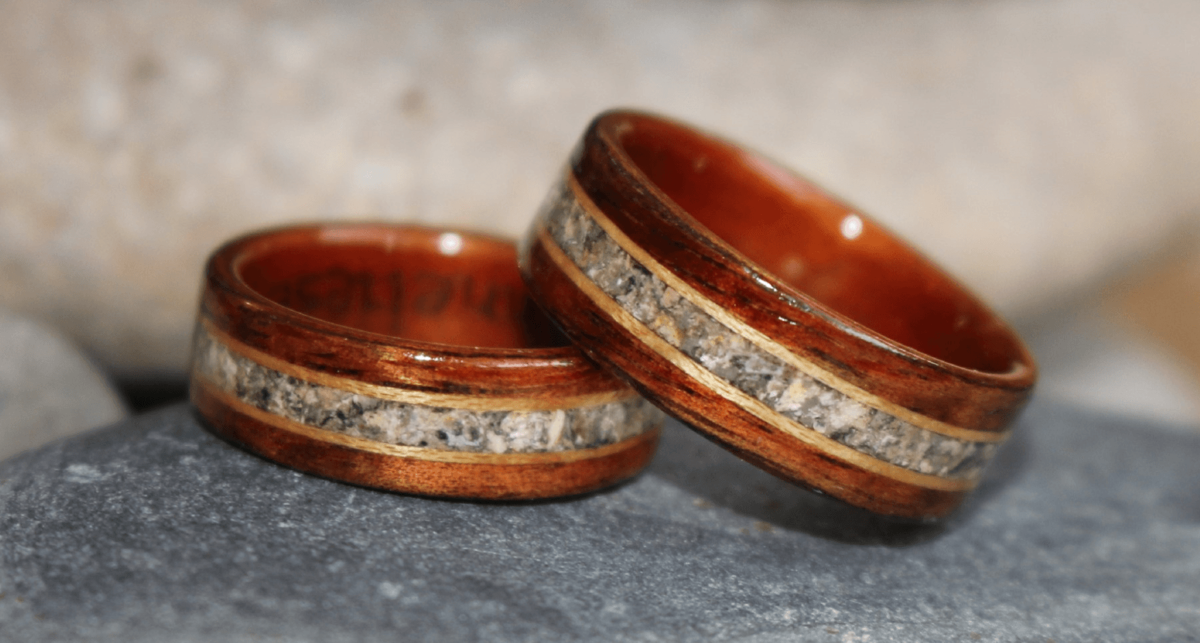 A set of wooden memorial rings made in memory of two babies for the mom and dad. One ring rests on the other.