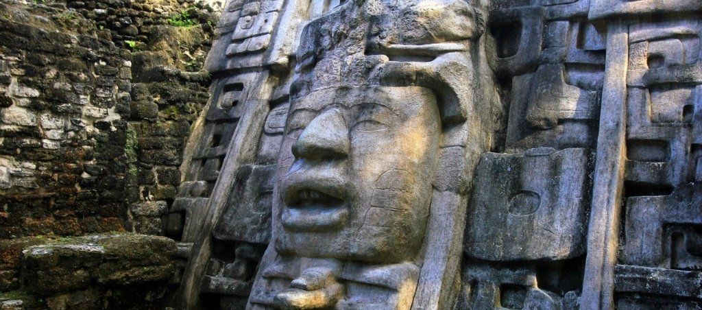 Eine große Statue mit dem Gesicht eines Mannes ist in eine Steinmauer gehauen.