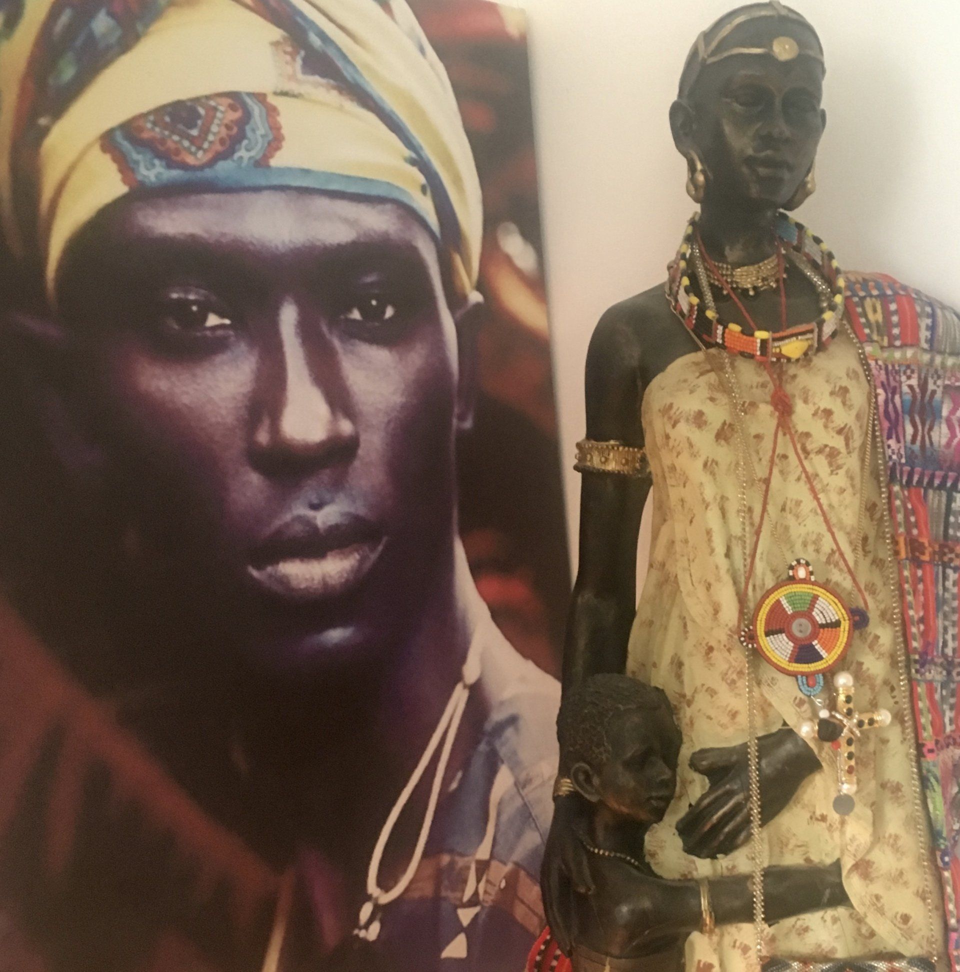 Eine Statue einer Frau, die neben einem Bild eines Mannes mit Turban steht