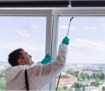 Exterminators Spraying The Window — Pest Control Technicians in Parlin, NJ Exterminators Spraying The Window — Pest Control Technicians in Parlin, NJ