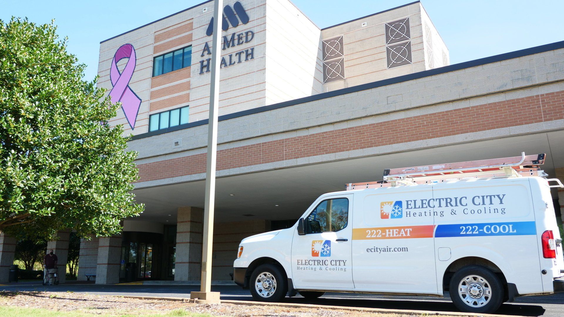 An electric city van is parked in front of a building