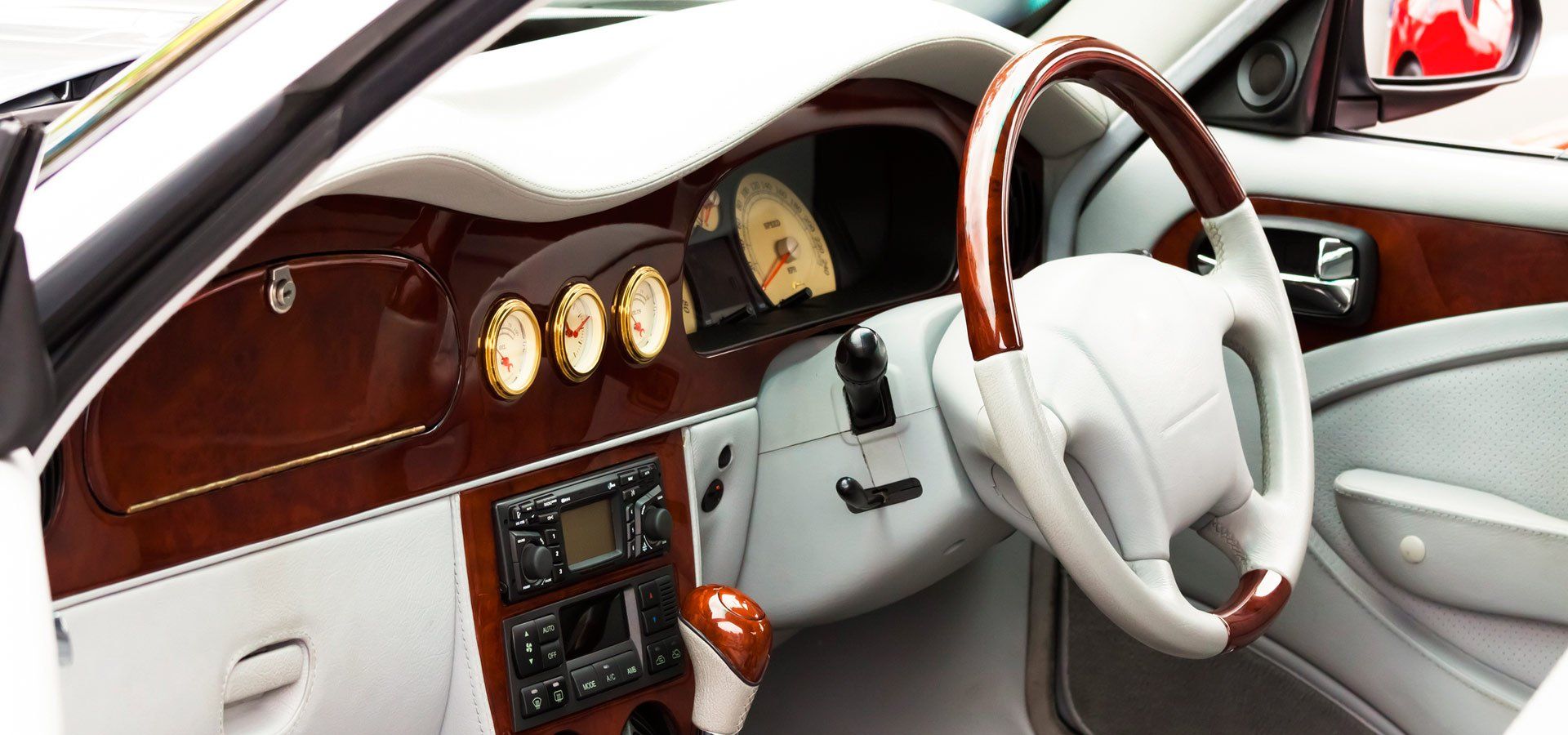 Car interior with wood grain dashboard and steering wheel.