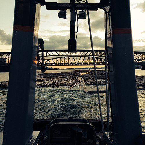 A tug boat towing logs in Vancouver, BC