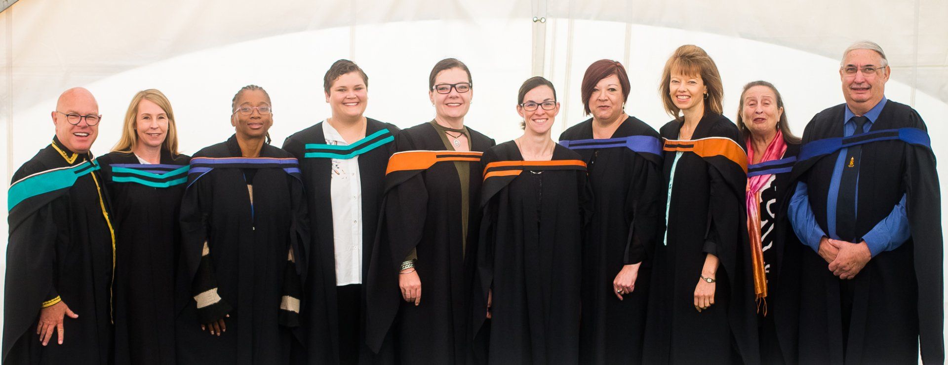 A group of people in graduation gowns are posing for a picture.