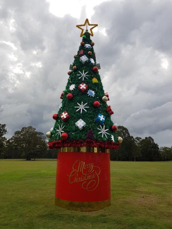 tall outdoor Christmas tree on red stand