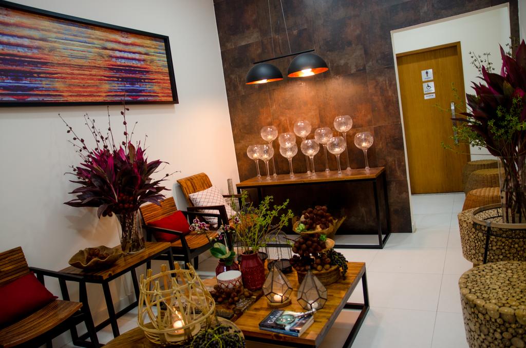Uma sala de estar com uma mesa, cadeiras, velas e uma pintura na parede.