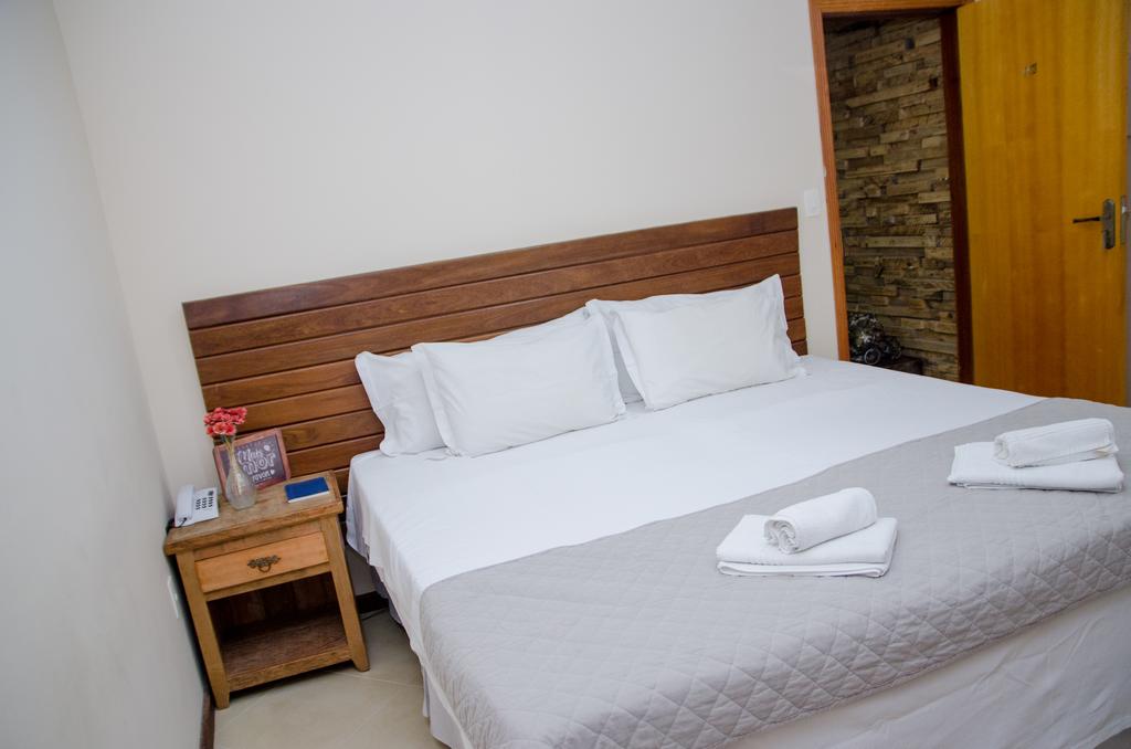 Um quarto com uma cama king size e uma mesa de cabeceira.
