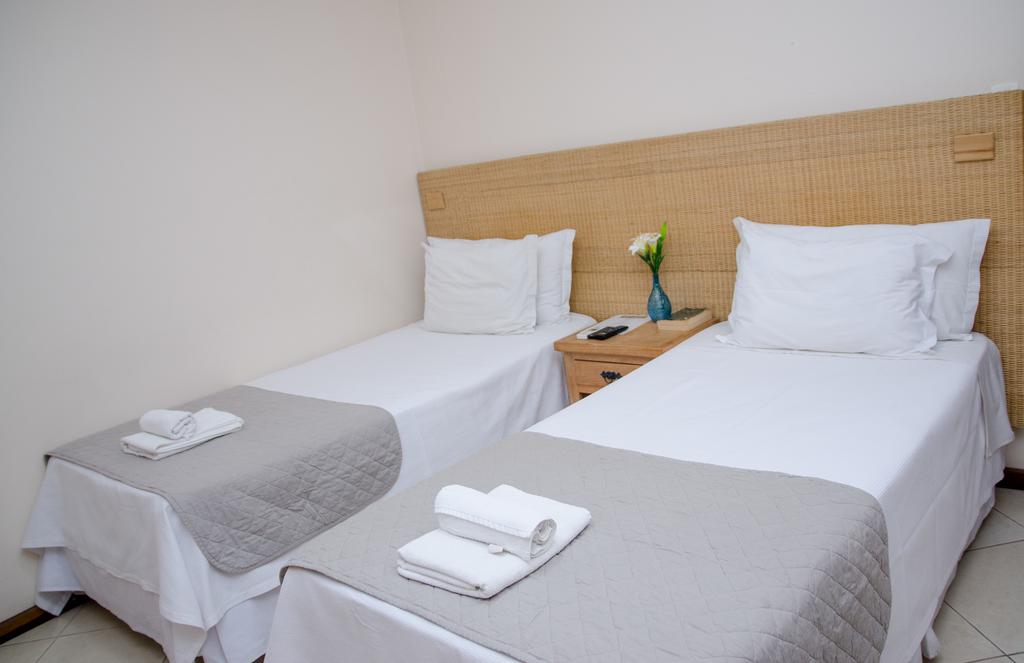 Um quarto de hotel com duas camas e uma mesa de cabeceira