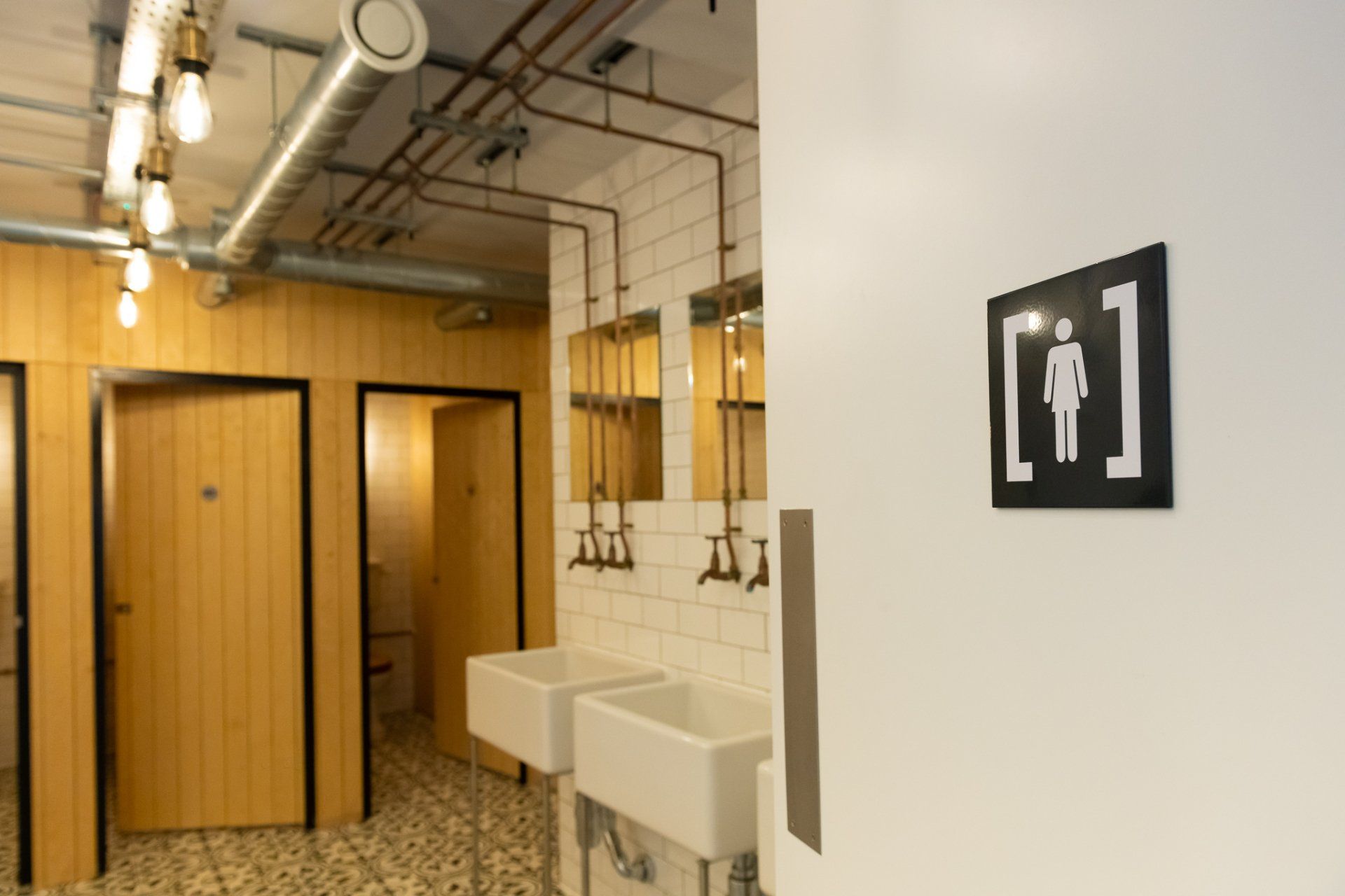 A bathroom with two sinks and a sign that says ' men ' on it.