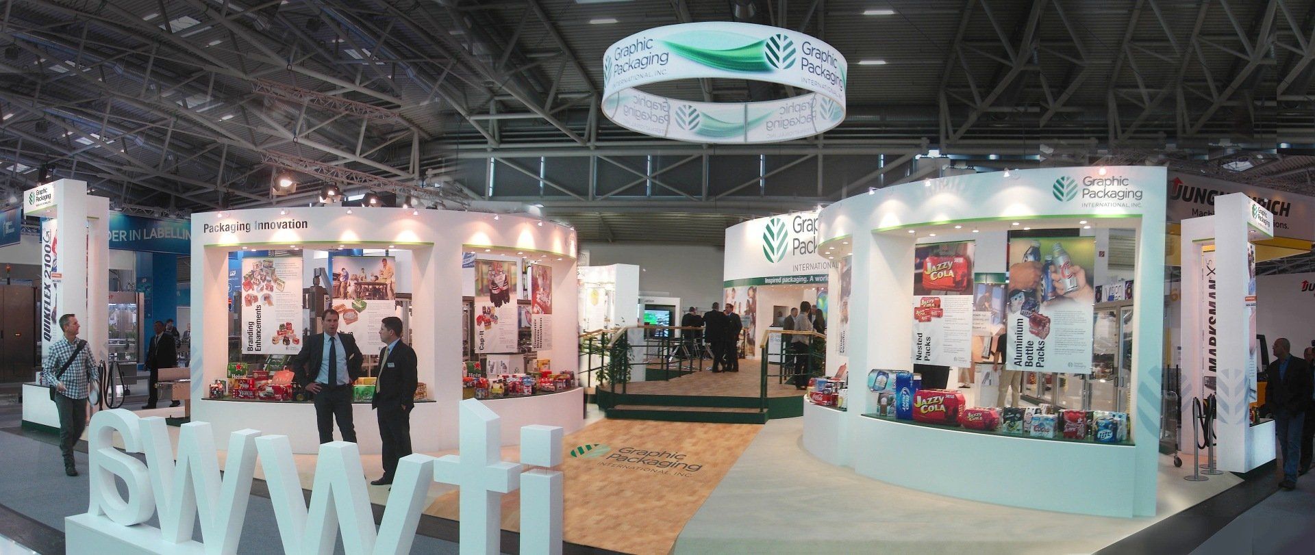 A group of people are standing in front of a booth at a convention.