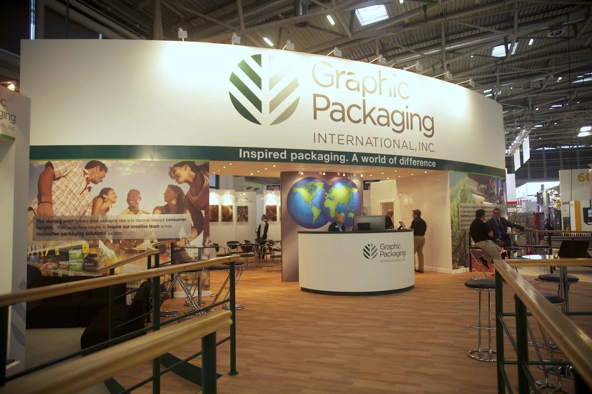 A graphic packaging booth with people standing around it
