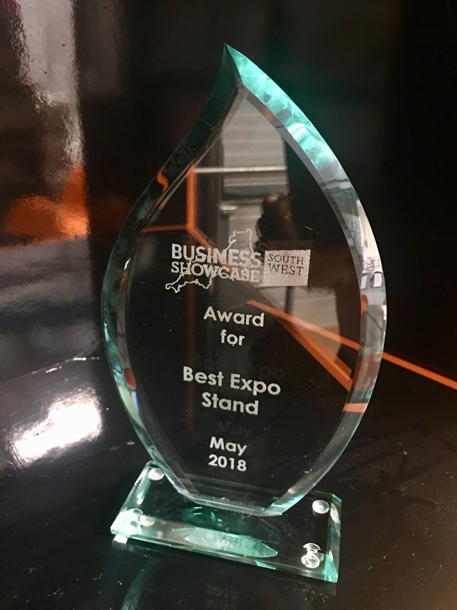 A glass trophy that says ' award for best expo stand ' on it