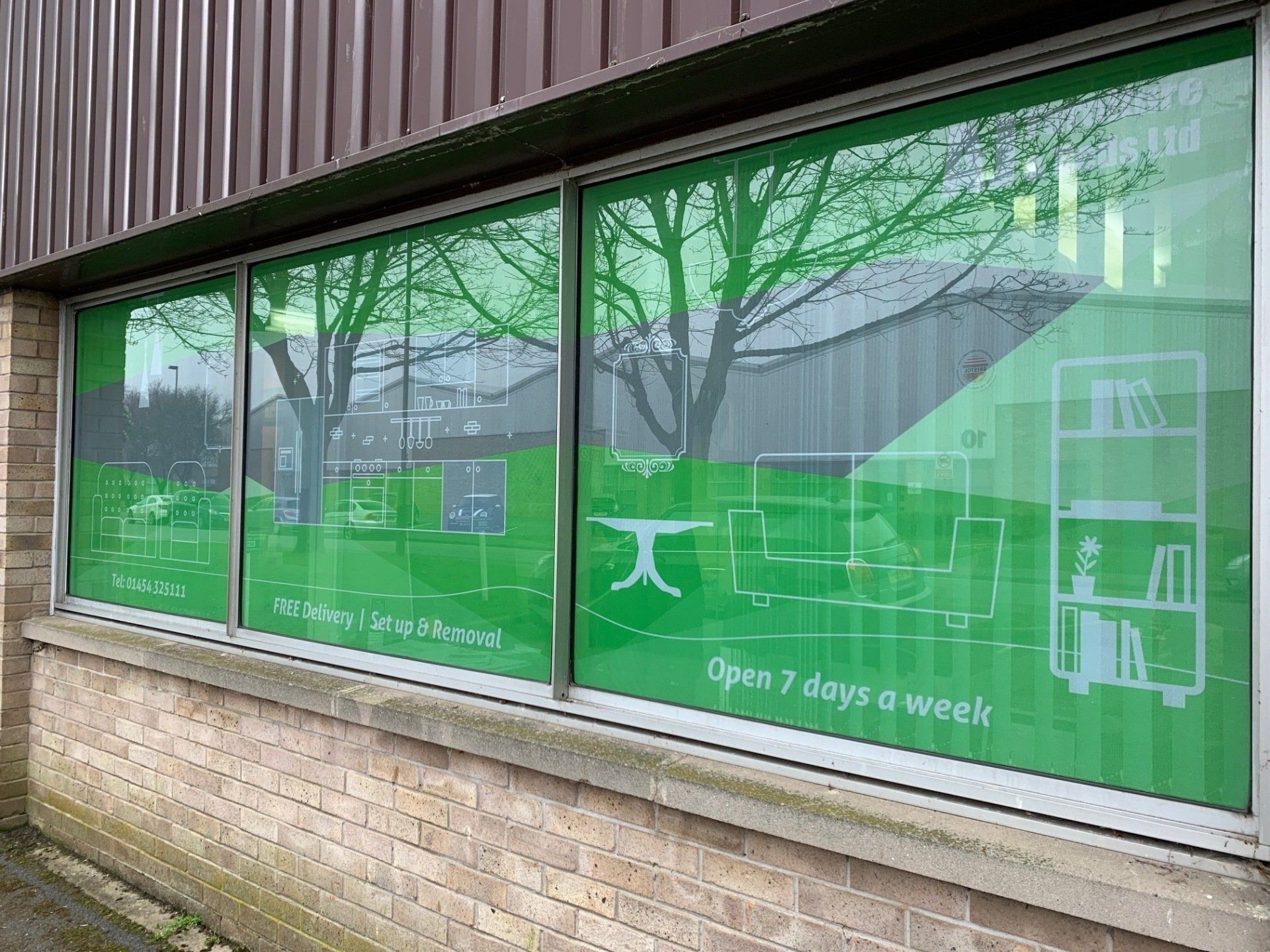 A brick building with a green window that says `` open 7 days a week ''.