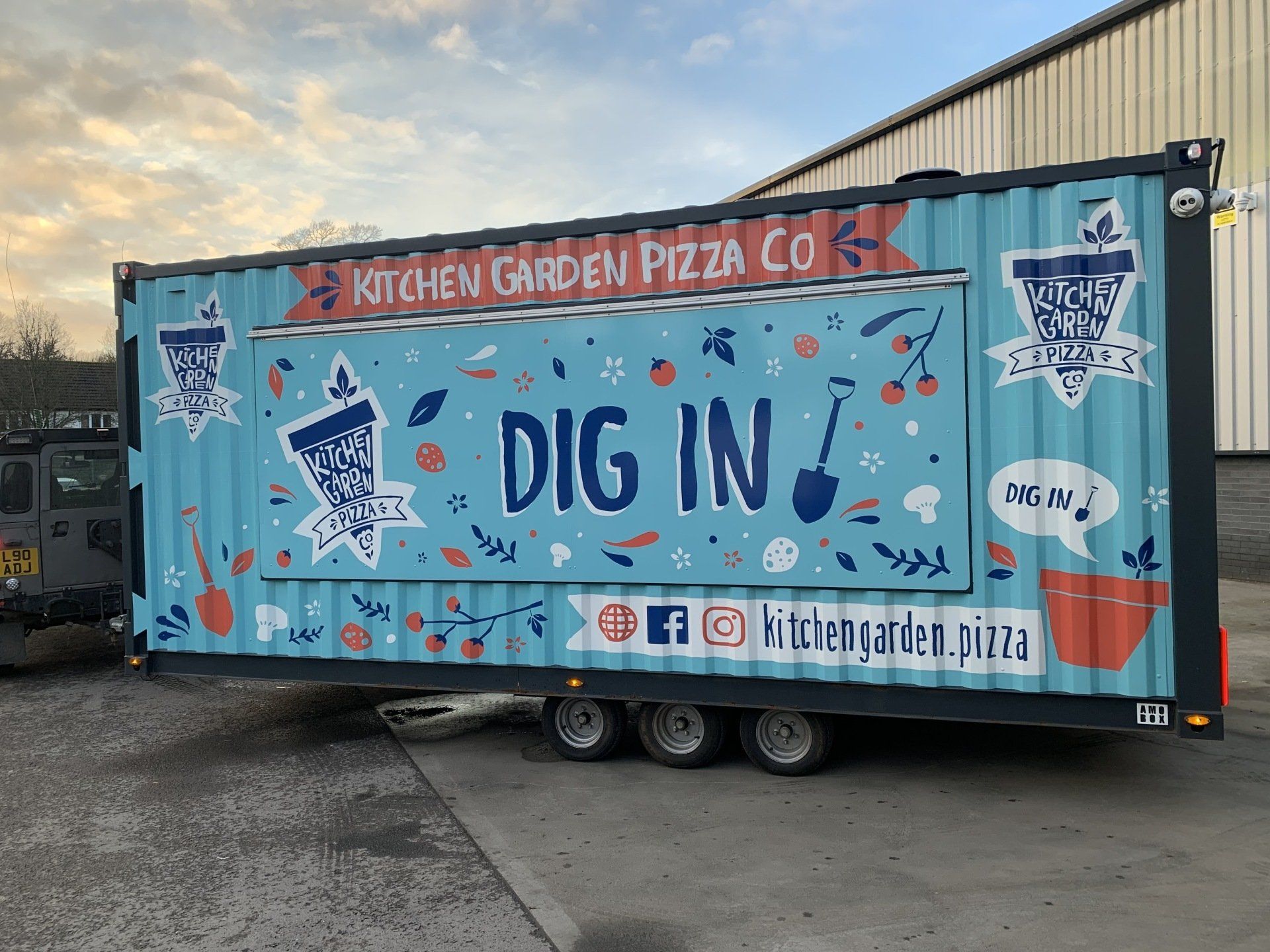 A kitchen garden pizza co. trailer is parked in a parking lot.