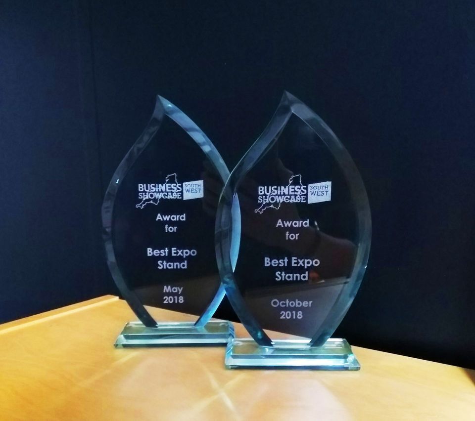 Two trophies that say best expo stand on them