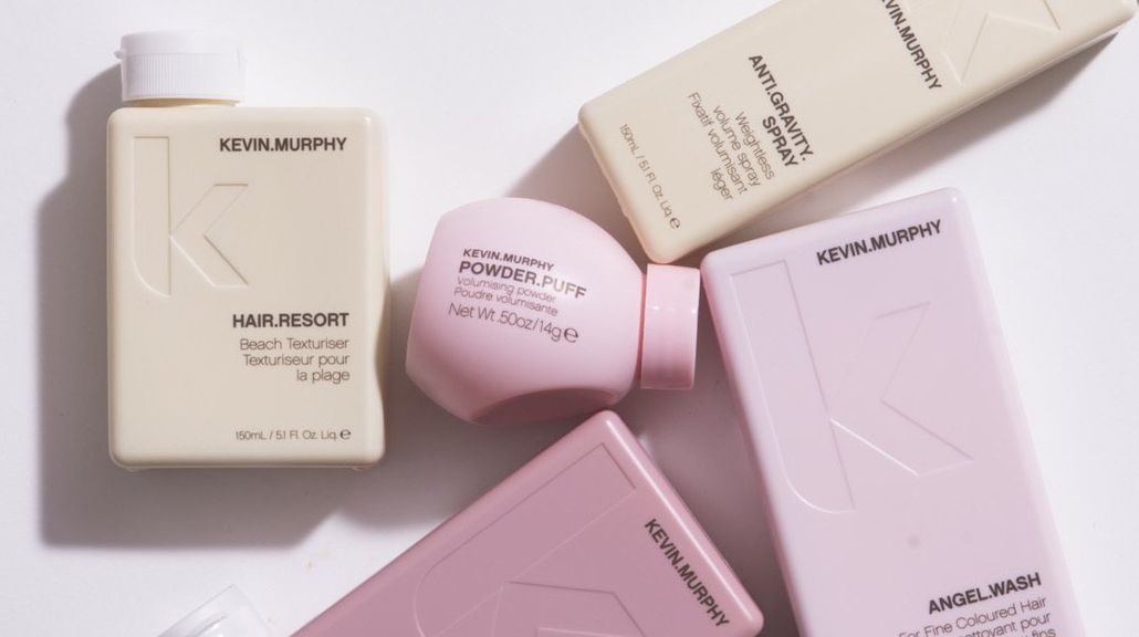 A group of Kevin Murphy hair products are sitting on top of each other on a table.