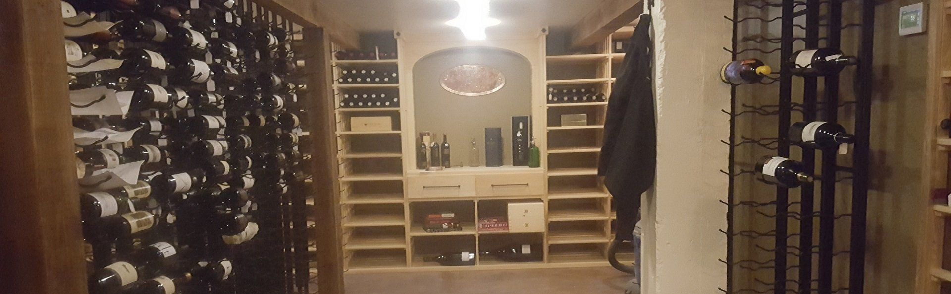 A wine cellar filled with lots of wine bottles and shelves.