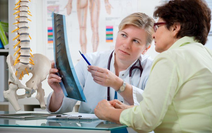Affordable Chiropractic Care — Chiropractor showing patient a x-ray in Brea, CA