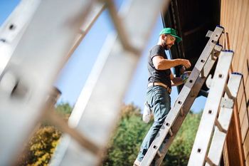man on ladder painting