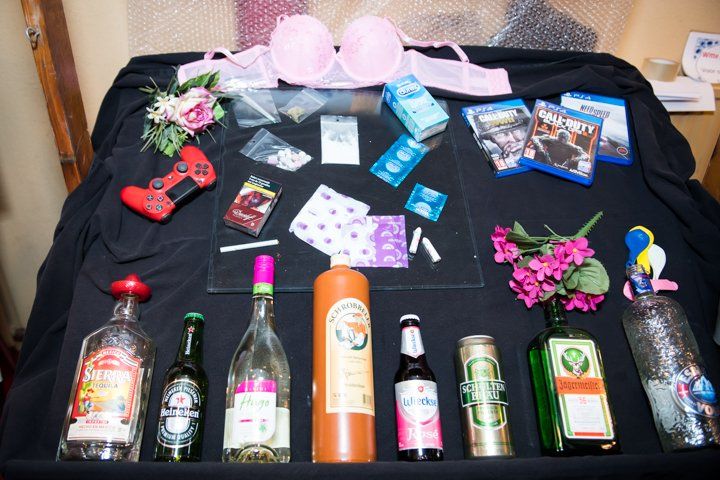 Tafelpresentatie: roze bh, flesjes, videogames, medicijnen, feestdecoraties en een gamecontroller.
