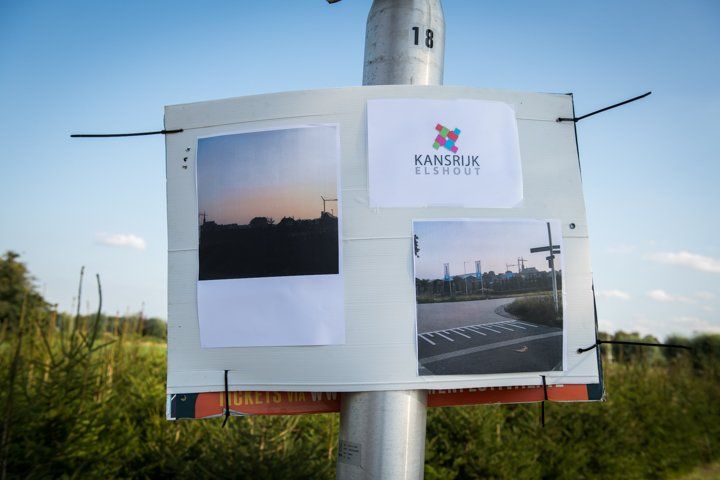 Bord op een paal met foto's van landschappen, het logo 