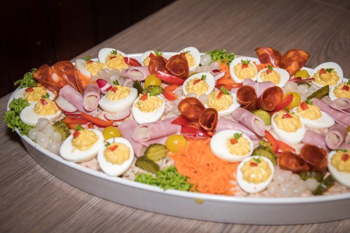 Ovale schotel met gevulde eieren, worst, ham en groenten.