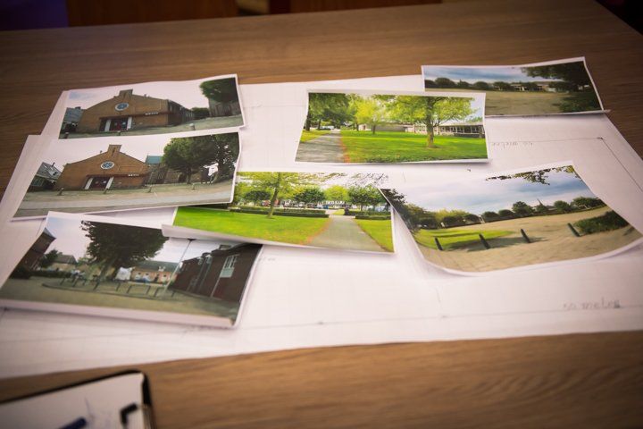 Foto's van bakstenen gebouwen en grasvelden verspreid over een witte achtergrond, mogelijk een plattegrond of bouwtekening.