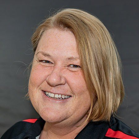 A woman with blonde hair and freckles is smiling for the camera.