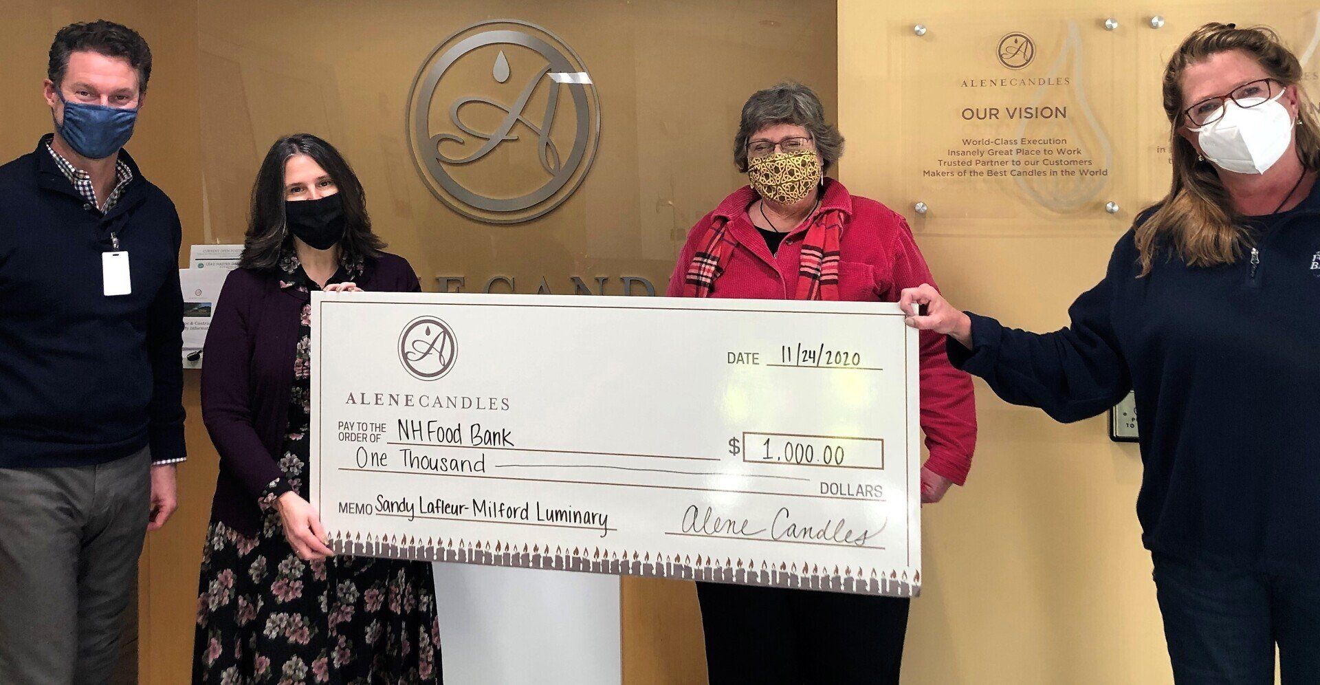 A group of people wearing masks are holding a large check.