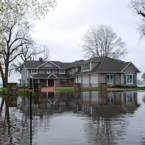 A large house is surrounded by flood water