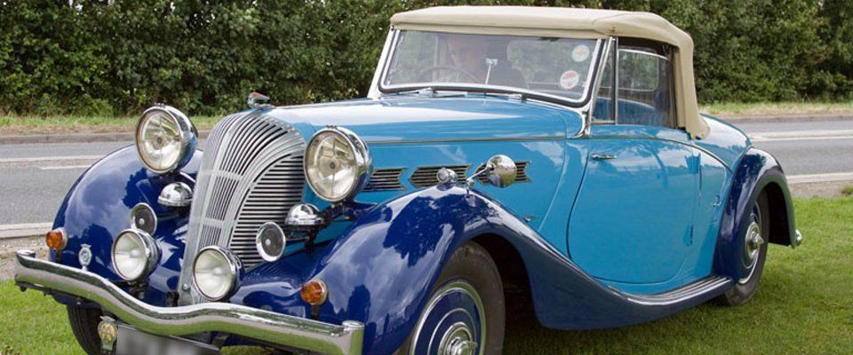 pale and dark blue veteran soft top car with running boards