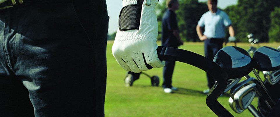 gloved hand pulling golf trolley