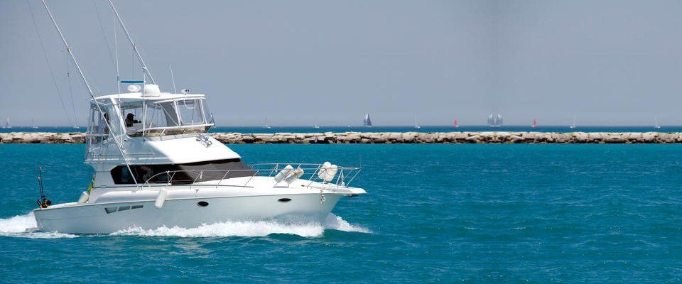 small white speedboat with jetty in background