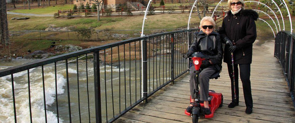 small red mobility scooter crossing wooden footbridge