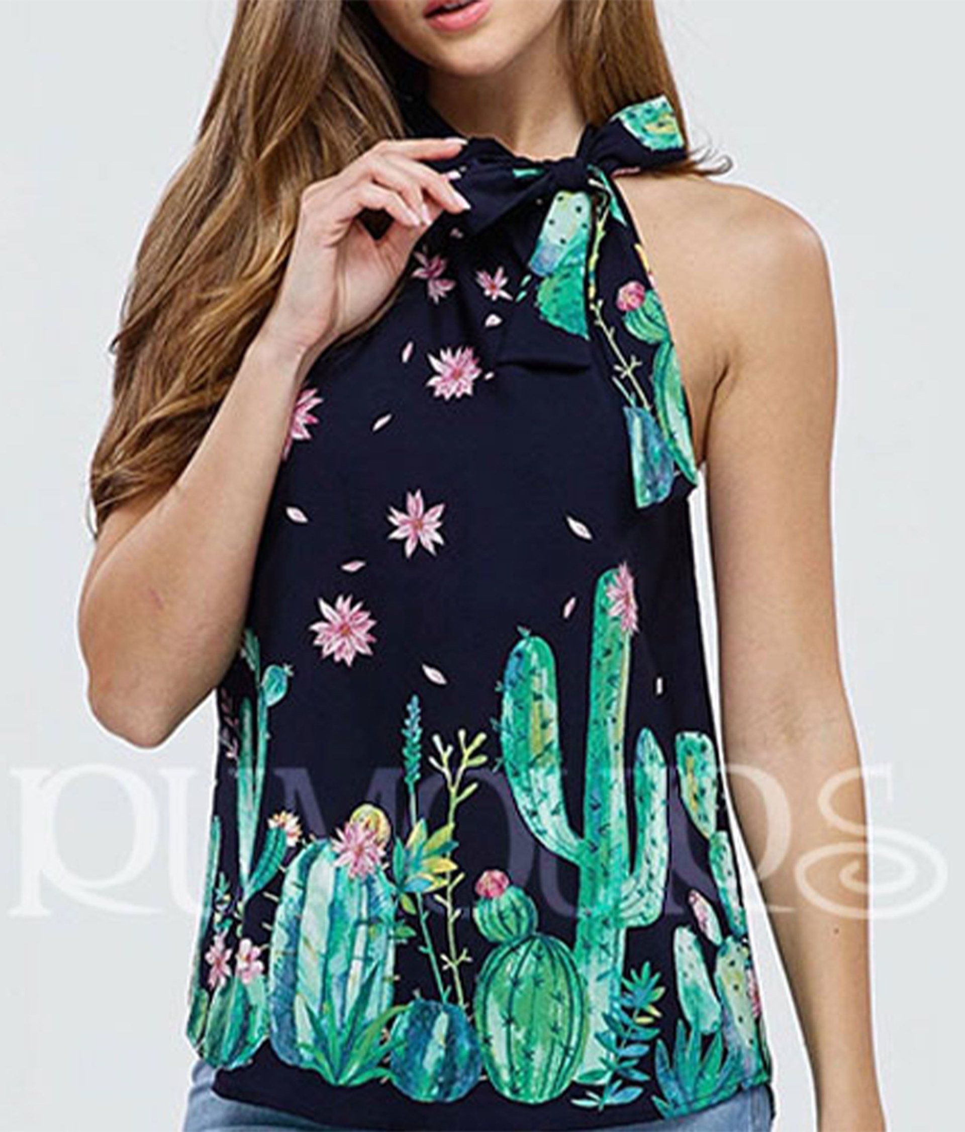 Woman wearing a navy halter top with a cactus print and a bow at the neck.